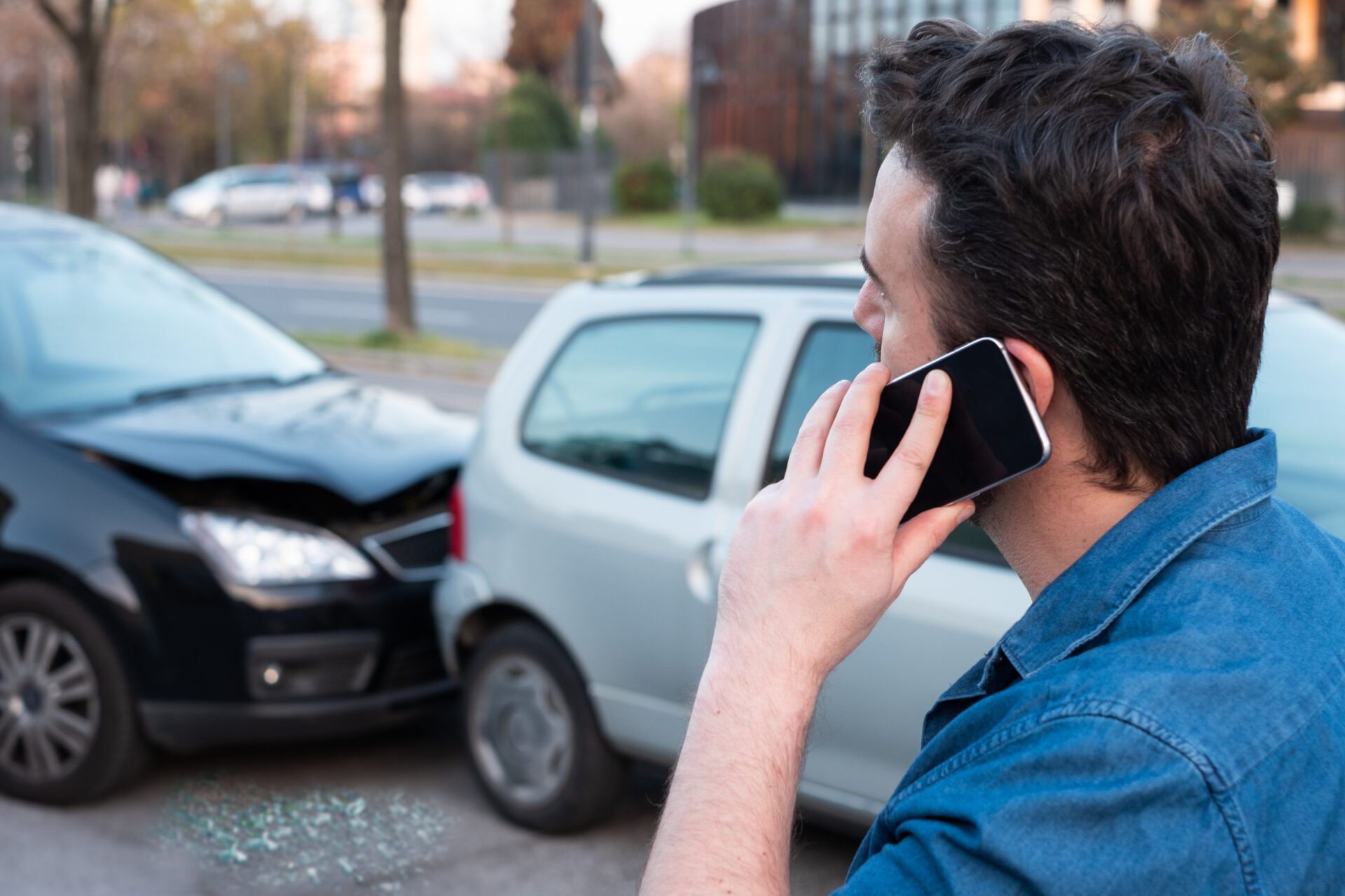 Man calling roadside service after car crash